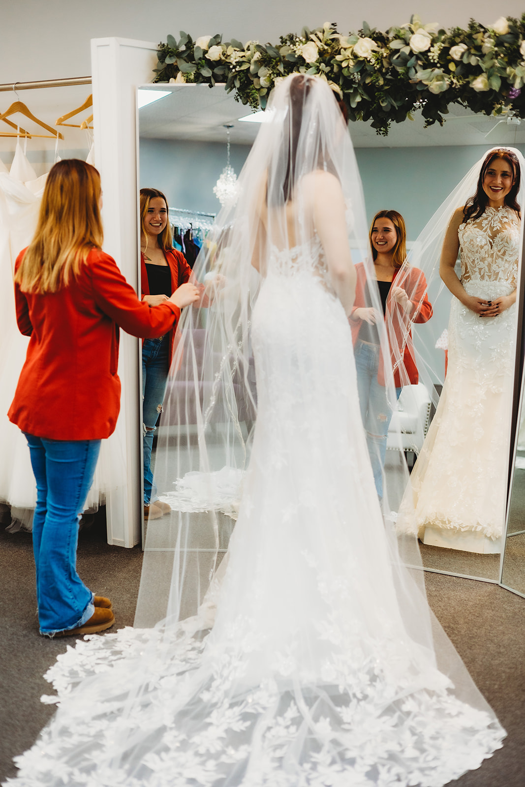 Bridal consultant assisting a bride-to-be in the mirror