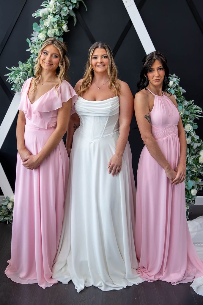 A beautiful bride with her bridesmaids standing next to her.