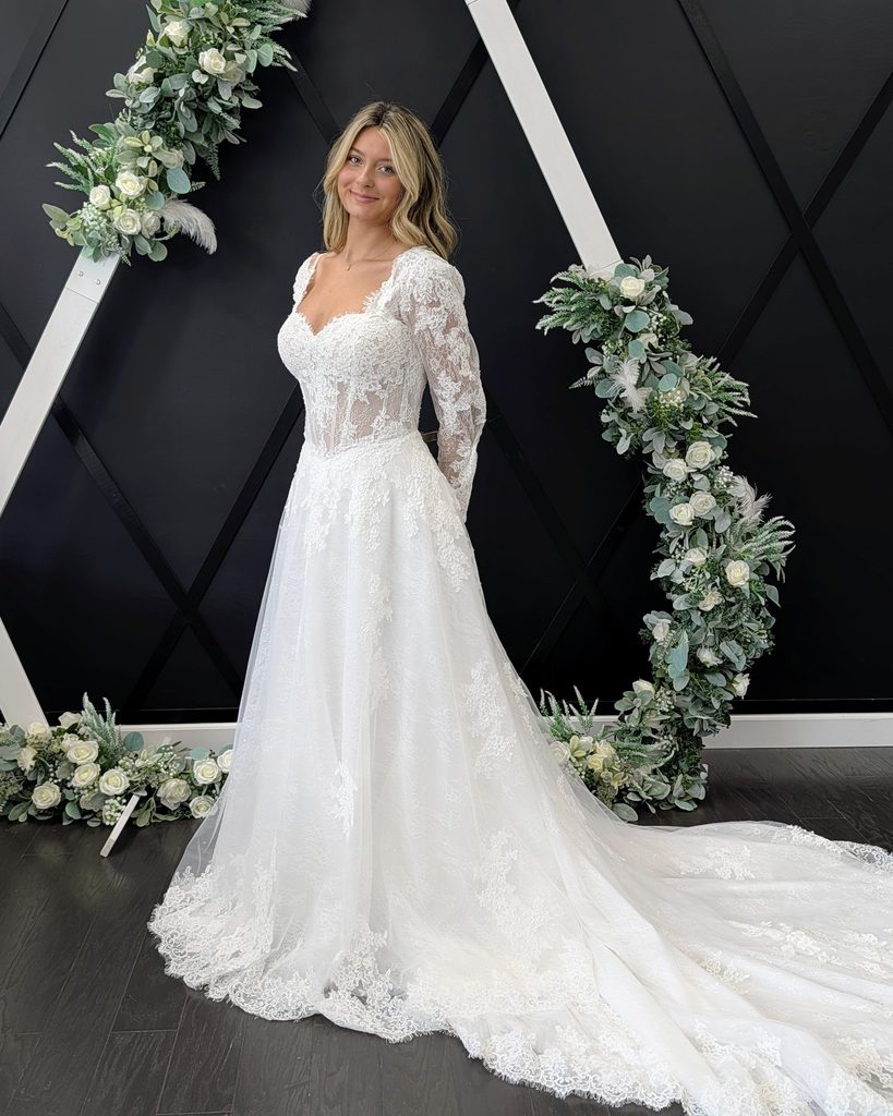 Bride wearing a lace long-sleeve A-line wedding dress at Catherine's Bridal Boutique